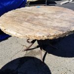 Travertine stone table, round with hammered edge and decorative wrought iron legs