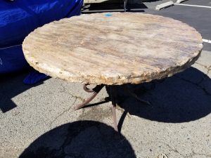 Travertine stone table, round with hammered edge and decorative wrought iron legs